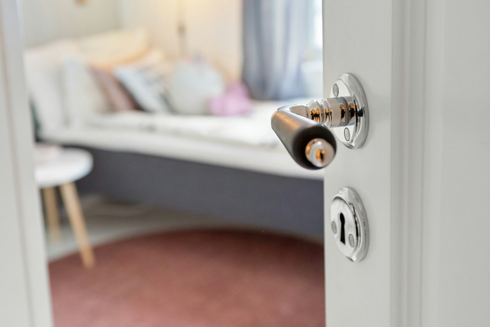 Handwerker zieht einen Türgriff mit Werkzeug an einer Tür fest