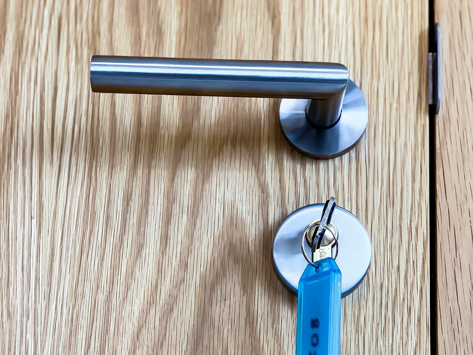 Runde Rosette eines Türgriffs sitzt leicht schief an einer Tür