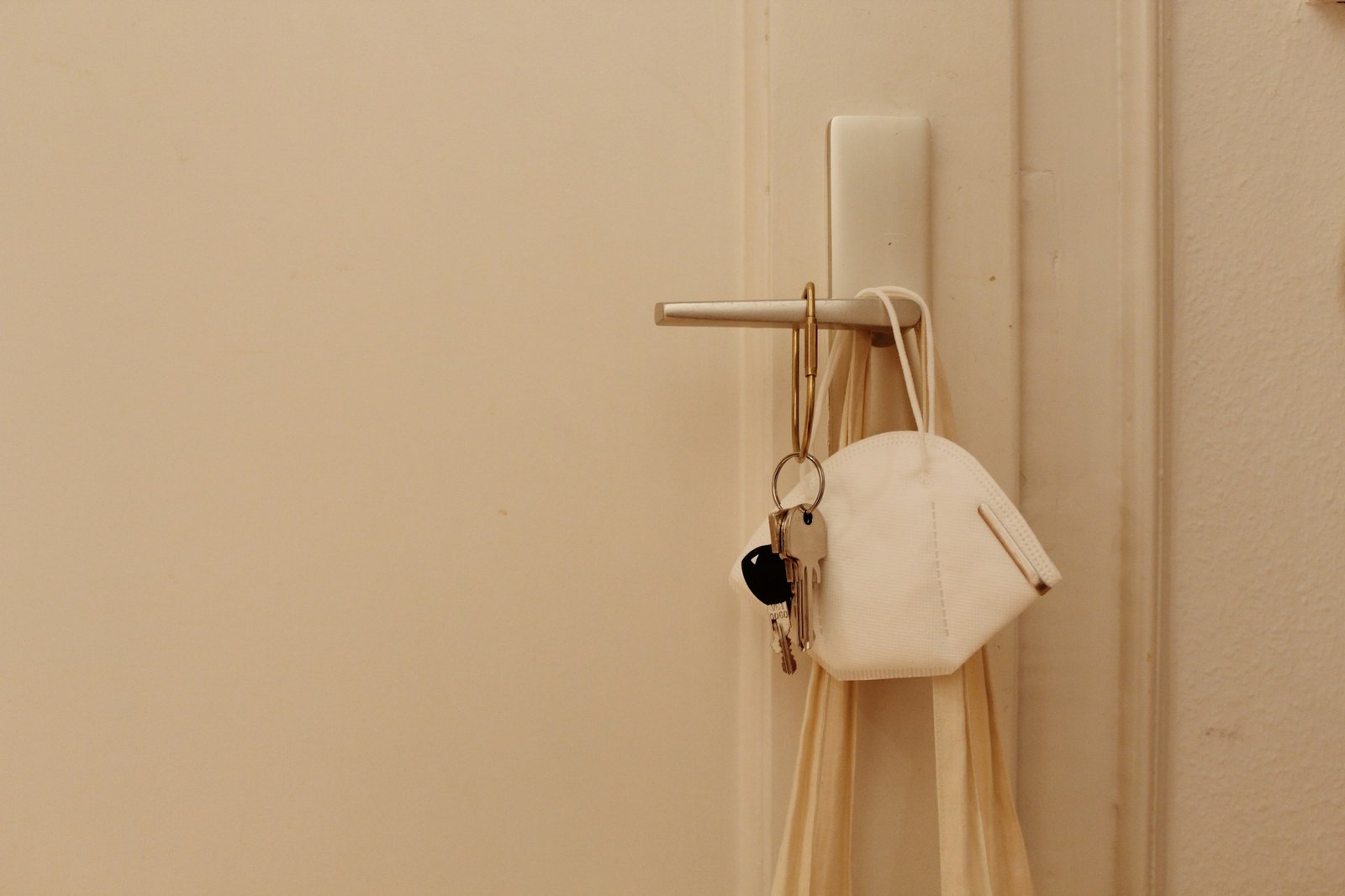 Hand hält eine leicht lockere Türklinke an einer Zimmertür