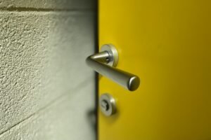 Metallischer Vierkantstift neben einem Türgriff