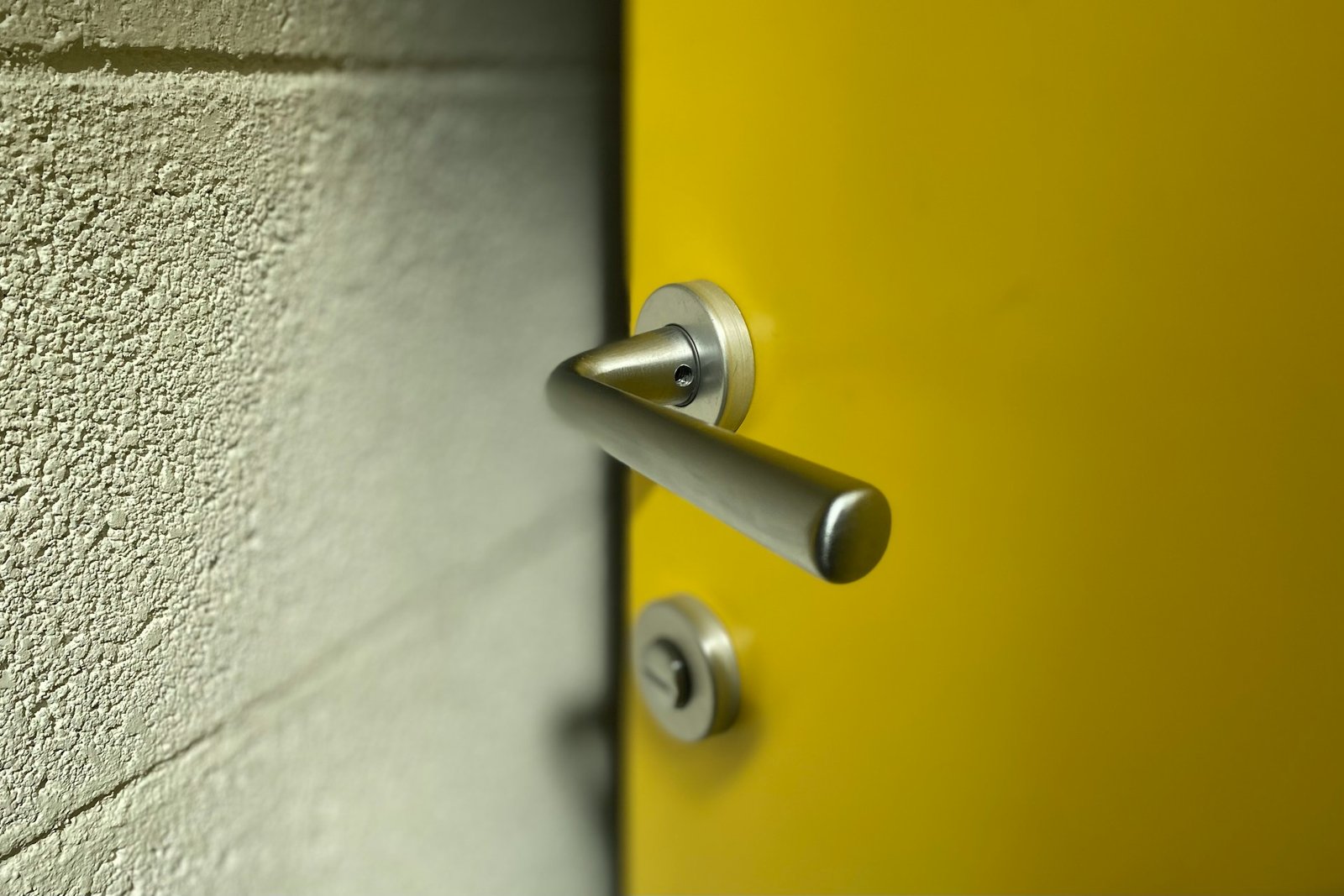 Metallischer Vierkantstift neben einem Türgriff